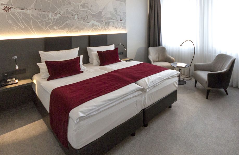 Modernes Doppelbett im Zimmer Pure mit roter Decke und roten Kissen