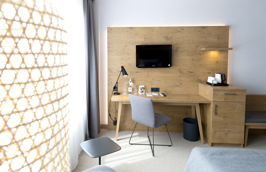 Schreibtisch im Doppelbettzimmer mit grauem Stuhl