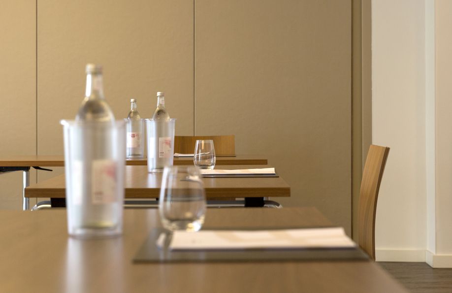 Heller Tagungsraum mit Tisch, Wasserflasche und Wasserglas