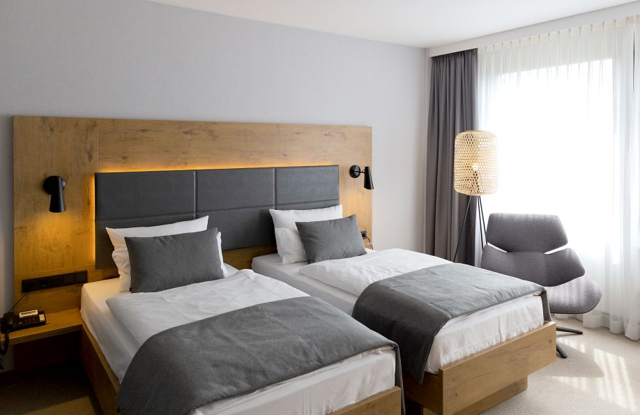 Doppelbett im Nature Zimmer mit grauen Bettdecken und Kissen